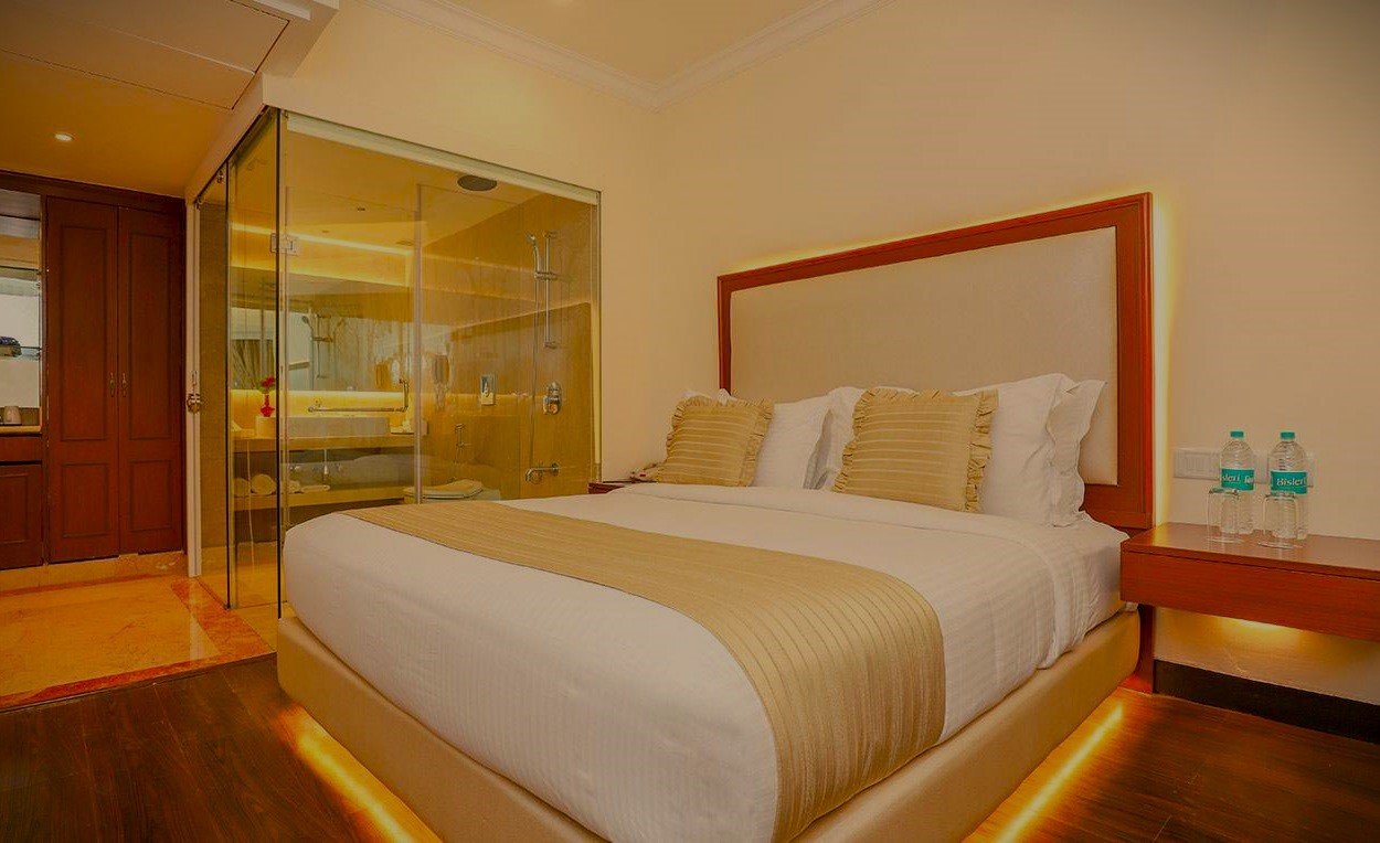 A neon hotel sign against a cloudy sky.